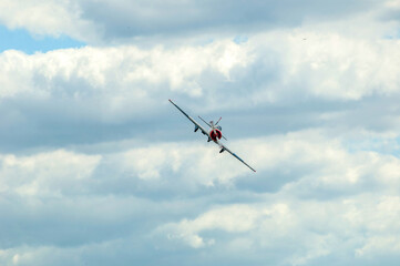Old turboprop plane performing maneuvers in the cloudy sky
