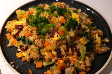 A plate of fried rice with vegetables.
