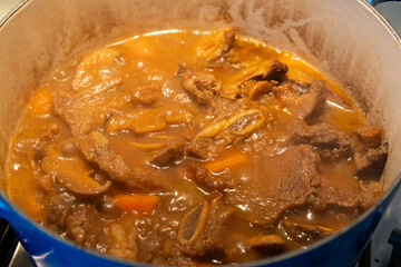 Beef stew cooking in a pot.