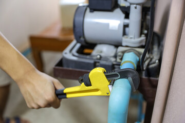 Plumber using a wrench to repair a water pipe. Concept of water pump maintenance fix water plumbing...