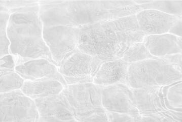 White water with ripples on the surface. Defocus blurred transparent white colored clear calm water surface texture with splashes and bubbles. Water waves with shining pattern texture background.