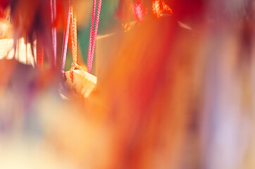 神社で奉納されている色とりどの絵馬の紐を写した写真