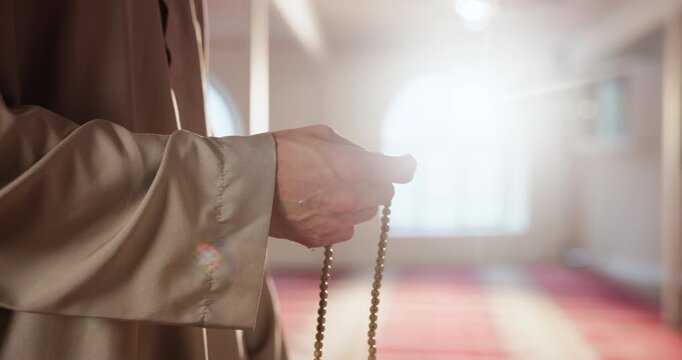 Arabic, hands and person with prayer beads for religion, worship and remember of Allah with quran recitation. Mosque, islamic man and praise with tasbih for faith, belief and spiritual with devotion
