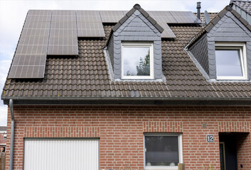 solar panels on the roof of a small house in Europe
