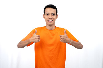 Portrait of a young Asian man wearing an orange t-shirt giving a thumbs up, okay, agree sign....