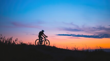 Obraz premium Serene Cyclist Silhouette: Riding on Hilltop at Dusk