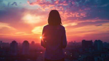 Fototapeta premium Serene Sunset Silhouette - Person Standing on Rooftop Enjoying Twilight Beauty