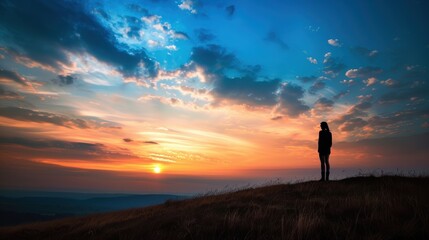 Fototapeta premium Serene Sunrise Silhouette - Person Standing on Hill in the Morning Light