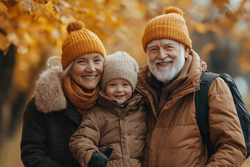 Fototapeta premium Happy Grandparents and Grandchild in Autumn Park Wearing Warm Clothing and Smiling