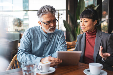 Business meeting between Japanese woman and mature caucasian man