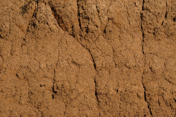 The surface of the dry land is covered with abstract patterns, shapes and textures. Excavated land. The soil looks fragile and is prone to landslides