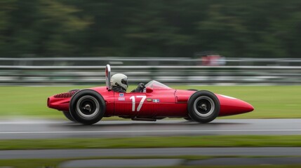 Red racing car speeds on track in daylight during race