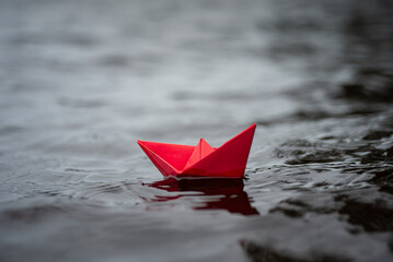 Farbiges Paierschiff auf einem See in den Wellen