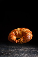 croissant isolated on dark background ,levitating on countertop.