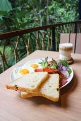 breakfast or bread with sunny side up egg, sausage and vegetable and hot coffee