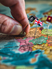 Obraz premium A hand is pointing at a map with flags on it