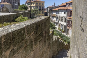 a narrow stone road leading down to a tower and a town