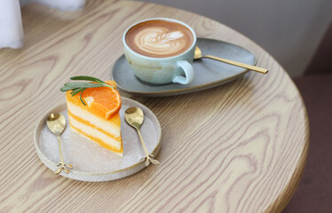 Hot latte art coffee cup with orange cake