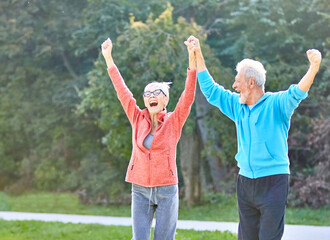 senior fitness woman man active sport exercise together running jogging hand celebrate celebration happy raised arm success victory team achievement teamwork winner up winning freedom healthy fit