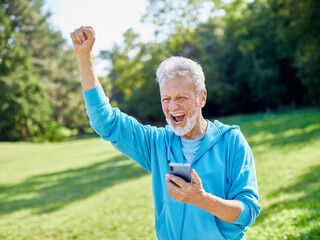 man outdoor senior happy retirement elderly phone mobile smartphone communication active nature park fun smiling old using internet connection healthy running jogging healthy