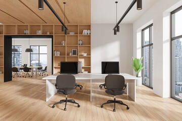 Business office interior with armchairs and desks, pc monitors near window