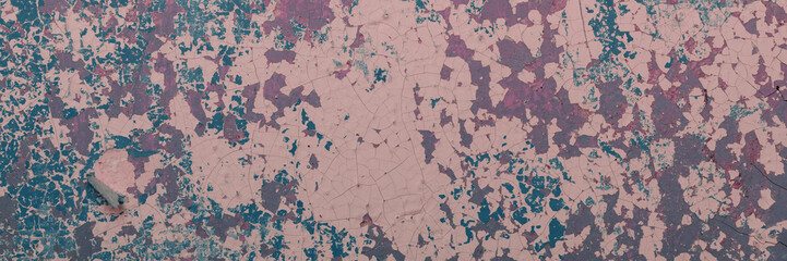 Peeling paint on the wall. Panorama of a concrete wall with old cracked flaking paint. Weathered rough painted surface with patterns of cracks and peeling. Wide panoramic grunge texture for background