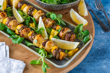 Grilled lamb, yellow peppers and baby potato skewers with green leaf salad