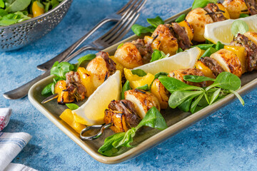 Grilled lamb, yellow peppers and baby potato skewers with green leaf salad