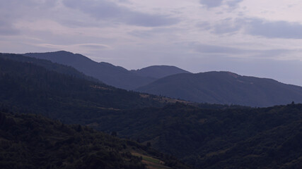 Gently pink sunset with the setting sun behind the mountains