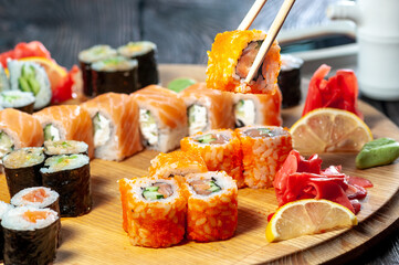 sushi set of different types on a wooden board with soy sauce