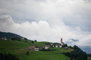 Charming Countryside Village Nestled Amidst Rolling Hills and Dramatic Cloudy Skies