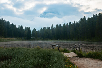 Serene Morning at the Misty Lake Surrounded by Majestic Pine Forests in Early Autumn
