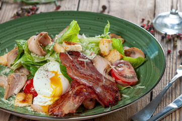 Caesar salad in the author's presentation on a green plate, macro photo