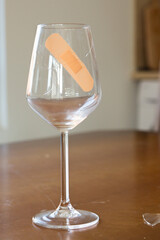 Broken glass of wine. Sadness after the breakup. Tape on the glass