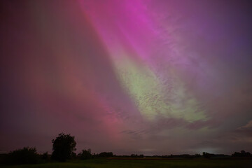 Vibrant Aurora Borealis Illuminating the Night Sky Over a Quiet Landscape