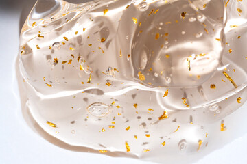 Luxury transparent cream gel with sparkling 24k gold particles, perfect for beauty products, wellness ads, high-end cosmetic presentations. Face creme, body lotion, moisturizer. Close up view.