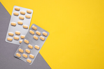 Antibiotic pills in blisters on color background, flat lay. Space for text