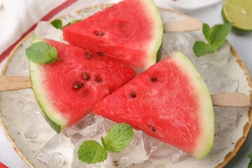Pieces of tasty watermelon, ice cubes and mint on table, closeup