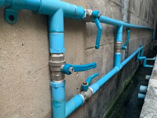 Water valve, rusty plastic pvc pipe, water pipe on the ground, Blue plastic water pipes on gray...