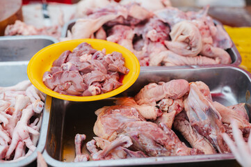 A pile of chicken meat is displayed in a yellow bowl. The meat is cut up and ready to be cooked