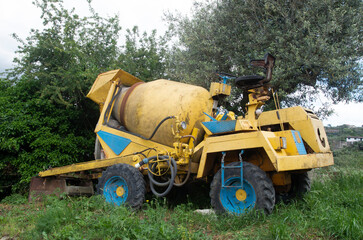 Old concrete yellow and blu truck without driver's cab