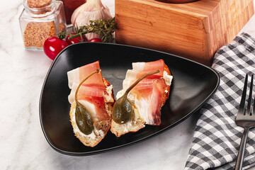 Bruschetta with jamon and caper berries