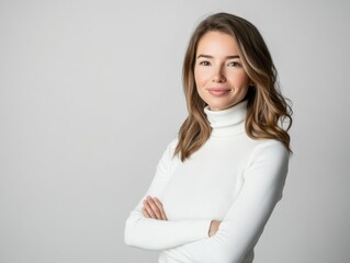 Studio portrait of a young happy woman looking to the camera, light grey background, wearing a turtle neck
