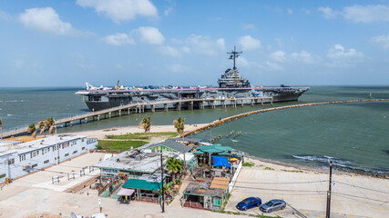 Corpus Christi, TX, USA, aerial view of USS Lexington, CV-16, a World War II - vintage Essex Class Aircraft Carrier with historic airplanes on flight deck. The Ship is a Museum and attraction