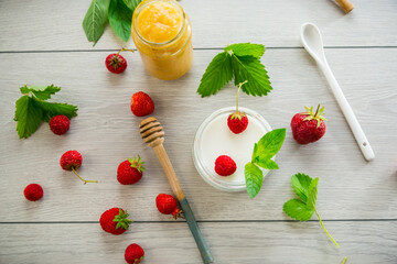 homemade sweet yogurt in a jar with strawberries, on a wooden table