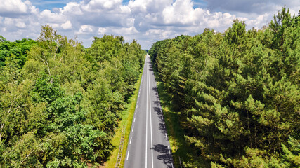 Aerial drone view of automobile road for cars in green forest, top view of landscape from above