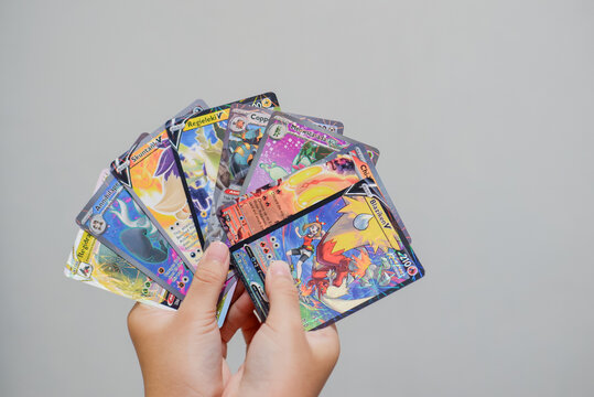 Hand of child holding pokemon cards. Indonesian youths playing these collectible cards for have fun