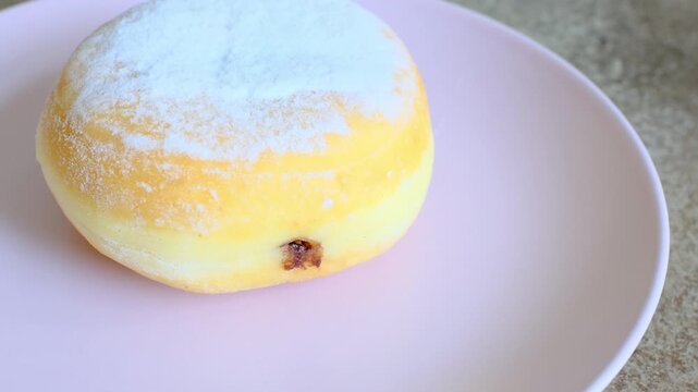 Close-up of berliner cake on a white plate and a cup of espresso