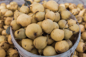 Yellow pears in a basket on the counter of a farmers market.