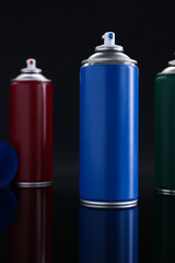 Many spray paint cans on black background